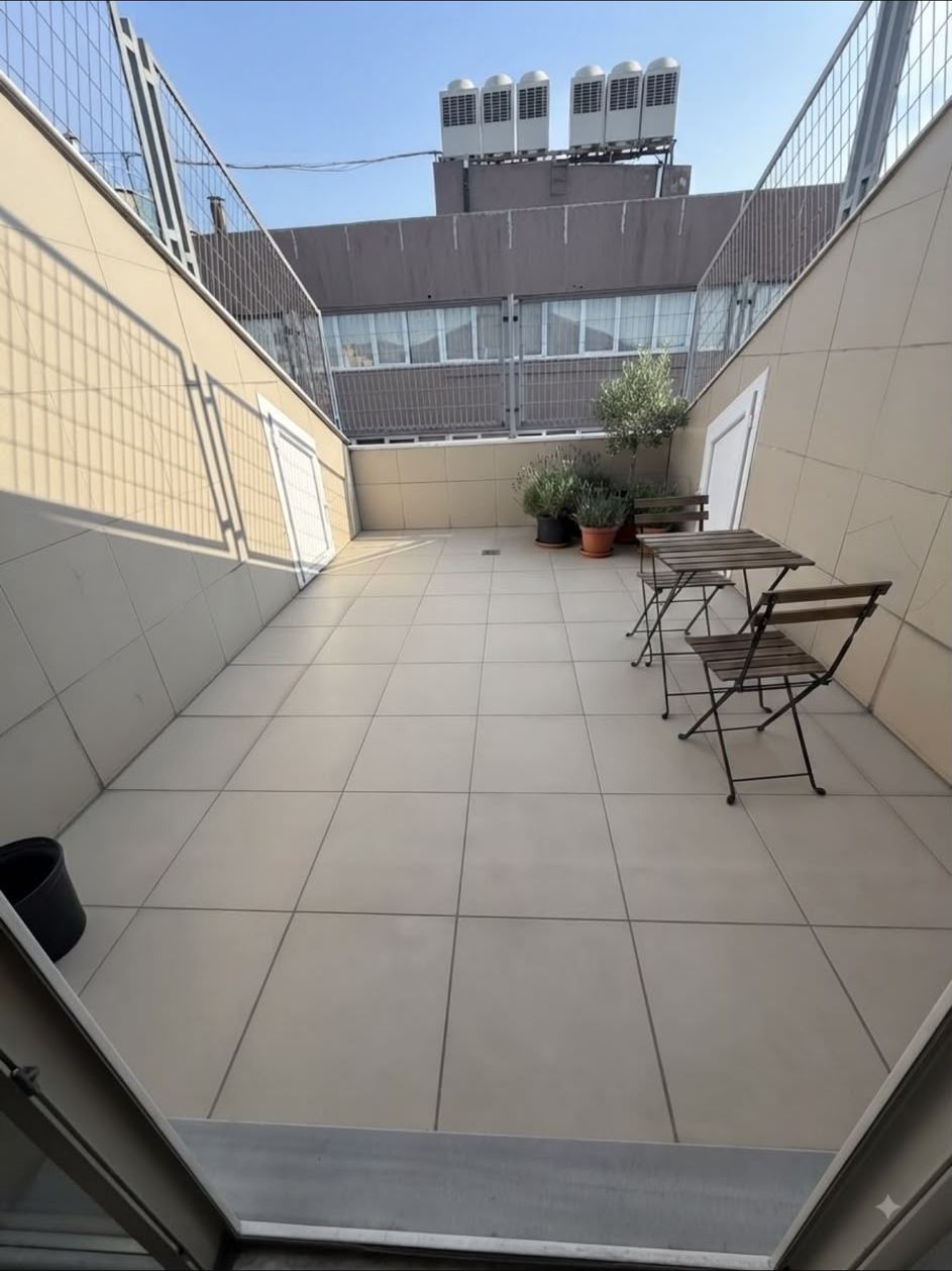 Yurdun üst katındaki fayans kaplı teras; katlanır masa, sandalyeler ve saksı bitkileri